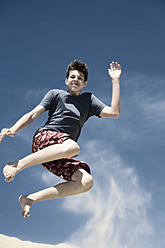 France, Teenage boy jumping on sand dune - MSF002744