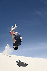 France, Teenage boy jumping on sand dune - MSF002743