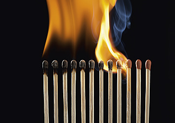 Burning matchsticks against black background, close up - WBF001359