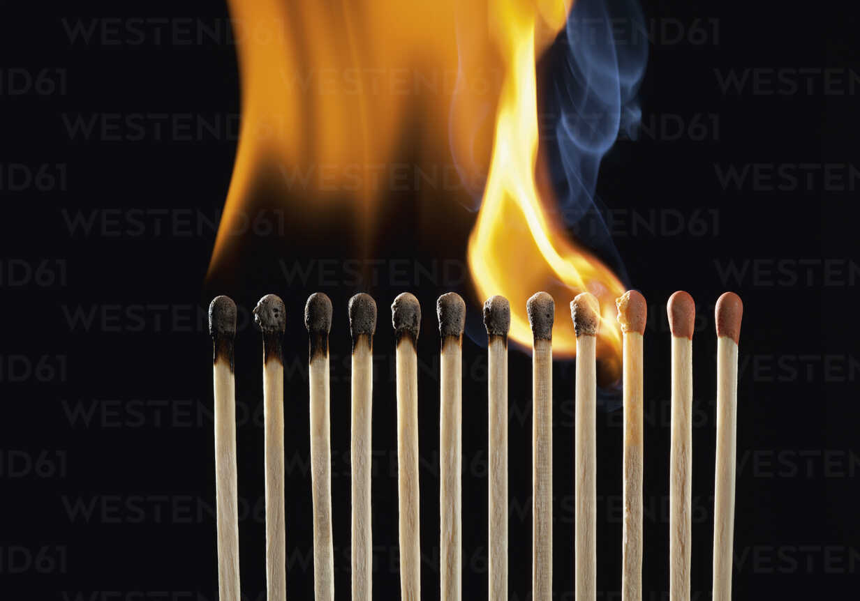 Burning matchsticks against black background, close up stock photo