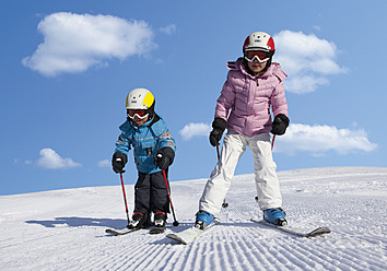 Switzerland, Boy and girl skiing in snow - WBF001479