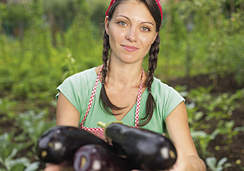 Deutschland, Porträt einer Frau mit Aubergine - WBF001409