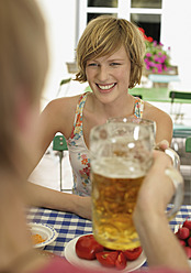 Deutschland, Junges Paar im Biergarten, lächelnd - WBF001416