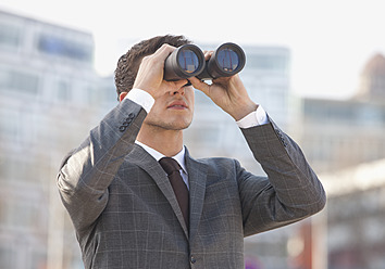 Germany, Young man looking through binocular - WBF001432