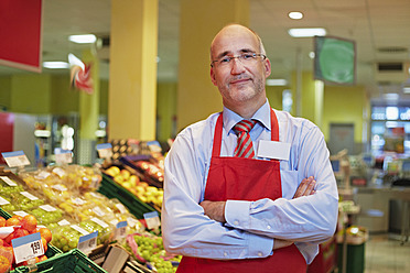 Deutschland, Köln, Älterer Mann stehend im Supermarkt, lächelnd, Porträt - RKNF000011