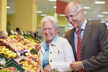 Deutschland, Köln, Älteres Paar im Supermarkt, lächelnd - RKNF000029