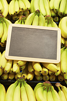 Germany, Cologne, Bananas with blackboard in supermarket - RKNF000091