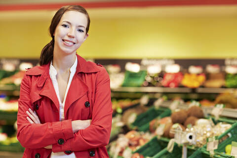 Deutschland, Köln, Junge Frau im Supermarkt, lächelnd, Porträt, lizenzfreies Stockfoto