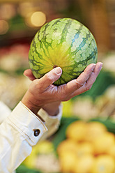Deutschland, Köln, Ältere Frau mit Wassermelone im Supermarkt - RKNF000103