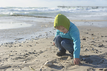 Deutschland, Mecklenburg Vorpommern, Junge spielt im Sand an der Ostsee - MJF000107