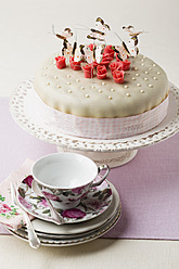 Torte verziert mit Schmetterlingen in Form von Marzipan, Tasse und Untertasse im Vordergrund - ECF000030