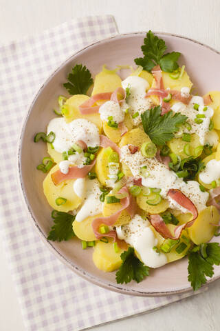 Kartoffelsalat garniert mit Frühlingszwiebeln, Petersilie und Mayonnaise, Nahaufnahme, lizenzfreies Stockfoto