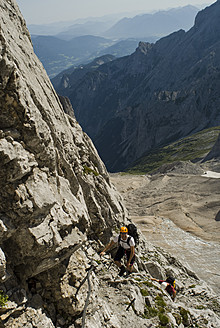 Germany, Bavaria, Mountaineer climbing steep wall - KAF000026