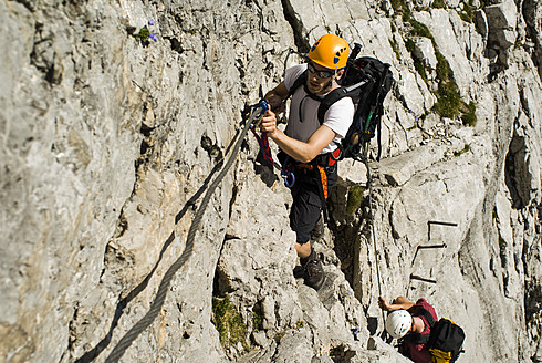 Germany, Bavaria, Mountaineer climbing steep wall - KAF000027