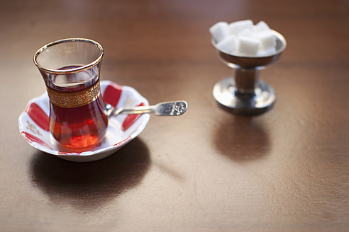 Turkey, Close up of turkish tea in glass with sugar cube on table - FLF000136