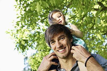 Germany, Cologne, Father carrying daughter on shoulders, smiling - PDYF000036