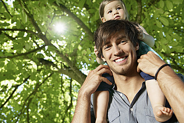 Germany, Cologne, Father carrying daughter on shoulders, smiling - PDYF000037