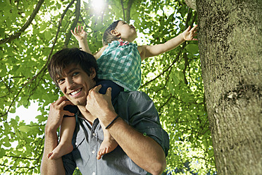 Germany, Cologne, Father carrying daughter on shoulders, smiling - PDYF000039