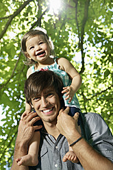 Germany, Cologne, Father carrying daughter on shoulders, smiling - PDYF000040
