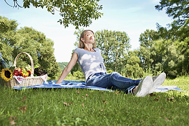 Deutschland, Köln, Junge Frau entspannt beim Picknick - PDYF000089