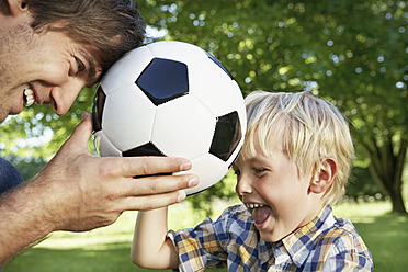 Germany, Cologne, Father and son playing with soccer ball - PDYF000104