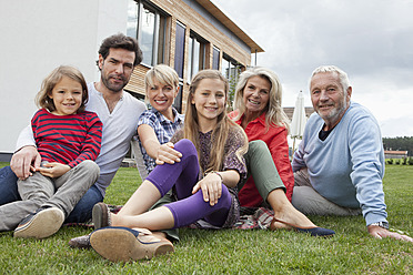 Germany, Bavaria, Nuremberg, Family sitting in front of house, smiling, portrait - RBYF000115