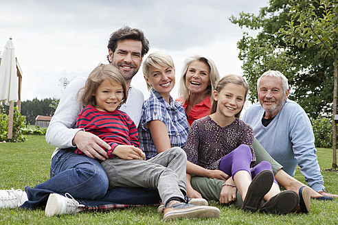 Deutschland, Bayern, Nürnberg, Familie im Gras sitzend, lächelnd, Porträt - RBYF000116