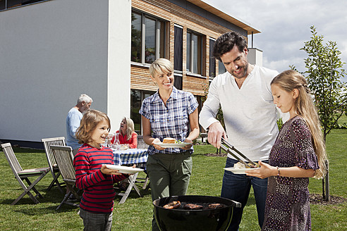 Deutschland, Bayern, Nürnberg, Familie barbucue im Garten - RBYF000126