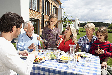 Germany, Bavaria, Nuremberg, Family barbecue in garden - RBYF000130