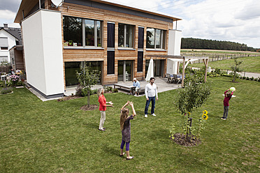 Deutschland, Bayern, Nürnberg, Familie spielt im Garten - RBYF000132