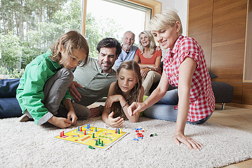 Germany, Bavaria, Nuremberg, Family playing board game together - RBYF000142