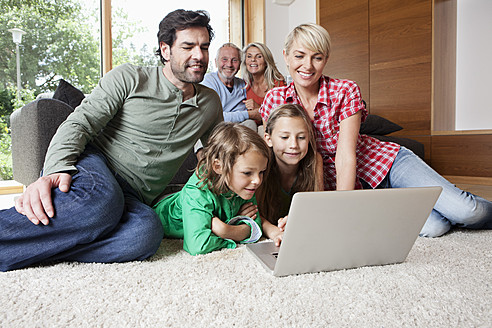 Deutschland, Bayern, Nürnberg, Familie mit Laptop im Wohnzimmer - RBYF000143
