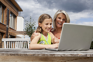 Germany, Bavaria, Nuremberg, Grandmother and granddaughter using laptop - RBYF000163