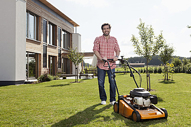 Germany, Bavaria, Nuremberg, Mature man with lawn mower in garden - RBYF000190