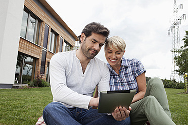 Deutschland, Bayern, Nürnberg, Älteres Paar benutzt digitales Tablet im Garten - RBYF000208