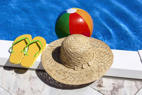 Österreich, Linz, Strandball schwimmt auf dem Wasser, Hausschuhe und Hut im Vordergrund, lizenzfreies Stockfoto