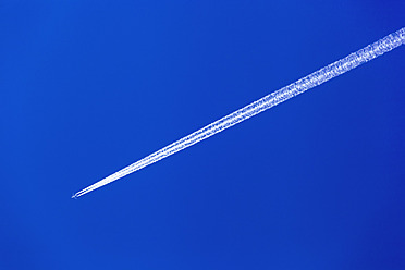 Österreich, Flugzeug mit Kondensstreifen gegen blauen Himmel - EJWF000083