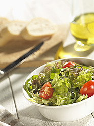 Mixed salad with bread and olive oil on table - CHF000005