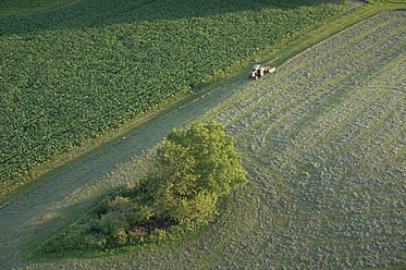 Germany, Bavaria, View of tractor with field and street - GNF001242