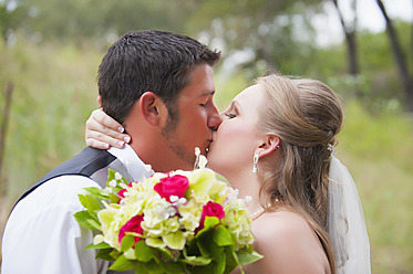 USA, Texas, Braut und Bräutigam küssen sich am Hochzeitstag - ABAF000263