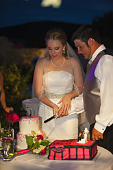 USA, Texas, Braut und Bräutigam schneiden Torte an - ABAF000241