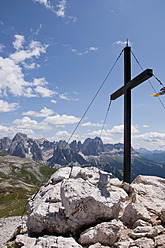 Italy, South Tyrol, Mountain summit with cross on Mt. Petz, Rosengarten in background at South Tyrol - UMF000433