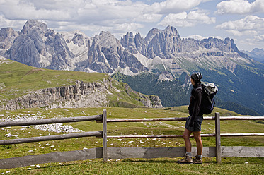 Italien, Mittlere erwachsene Frau mit Blick auf den Schlern zum Rosengarten in Südtirol - UMF000427