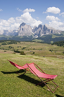 Italien, Südtirol, Liegestühle auf Almwiese in Richtung Langkofel und Plattkofel - UMF000396