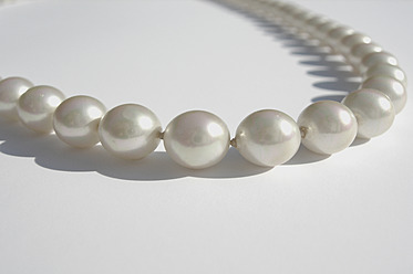 Nahaufnahme einer Perlenkette auf weißem Hintergrund - AXF000231