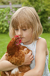 Germany, Brandenburg, Girl hugging hen, close up - BFRF000018