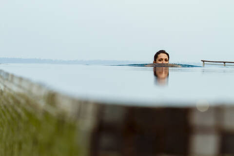 Indien, Kerala, Junge Frau entspannt im Pool, lizenzfreies Stockfoto