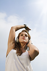 Germany, Berlin, Young woman listening music, close up - FKF000051