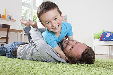 Germany, Berlin, Father and son having fun at home, smiling - RBF000951