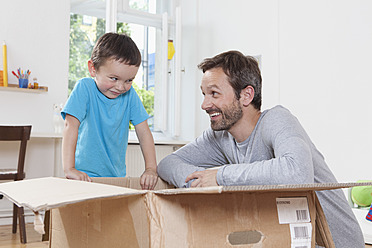 Germany, Berlin, Father and son opening parcel box - RBF000957